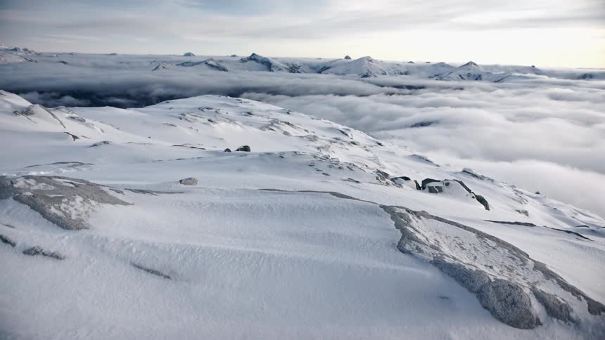 Clouds over a snow covered mountain range