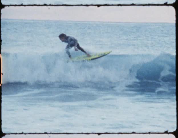 An old film of a man surfing in the ocean