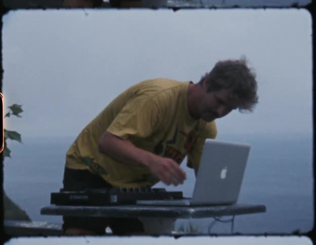 A filmstrip of two men setting up audio equipment and a laptop outside above a lake