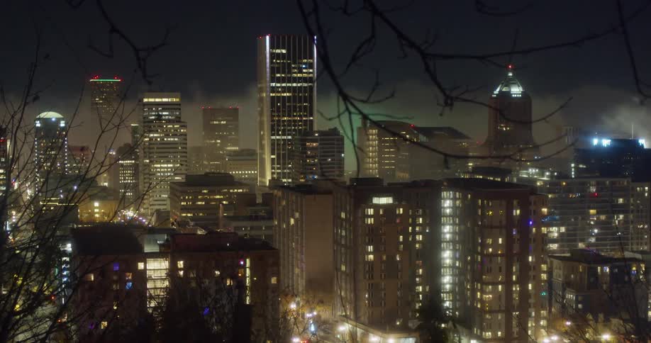 Time lapse of a city at night with low clouds and fog moving overhead