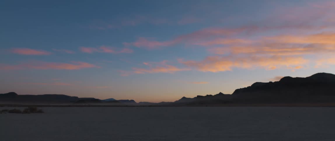 Sun set sky with silhouettes of mountains in the distance