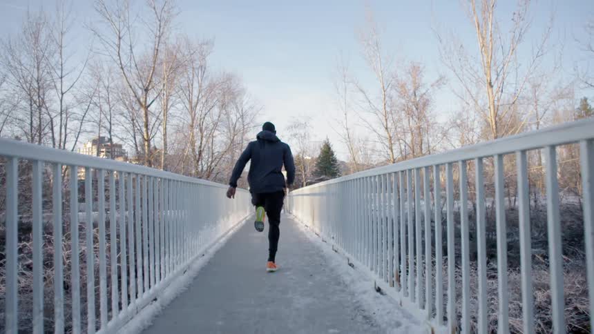 A man runs down a snowy path