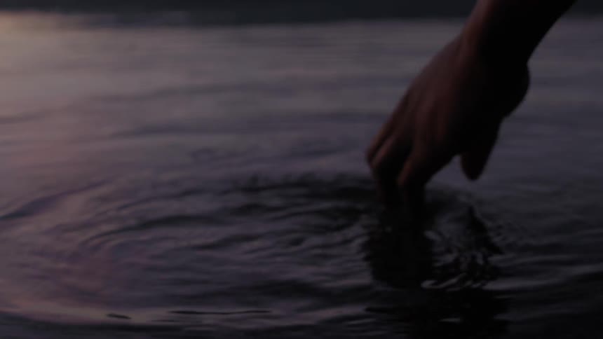 A hand is tracing around in water