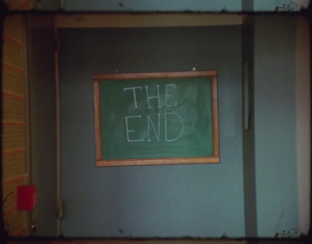 Small blackboard in the wall of a classroom with the words the end written in chalk