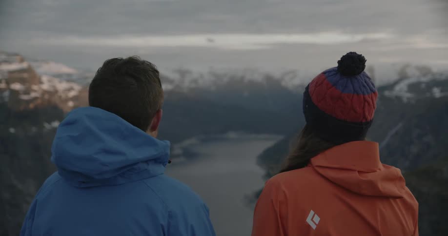 A couple overlooking a mountain river on a cloudy day