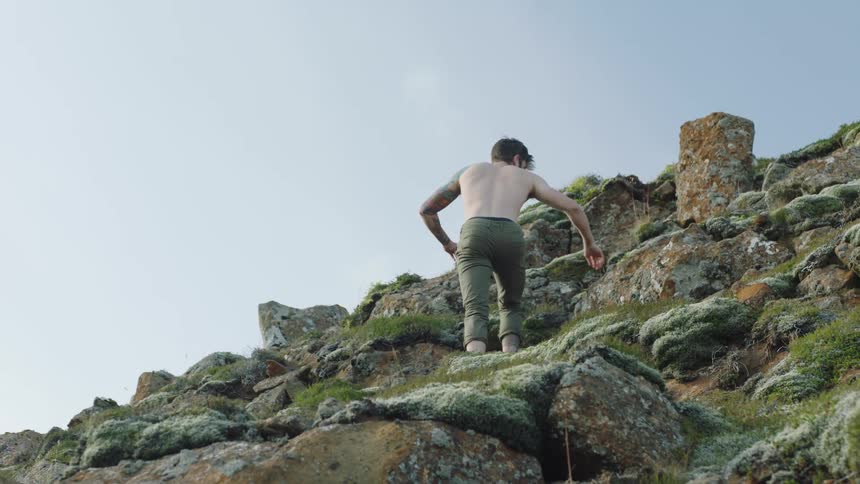 A man climbing up a rocky cliff