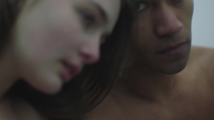 A naked man and woman lean against one another