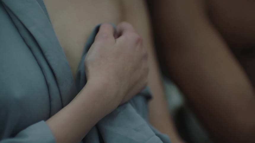 A close up of two people with one holding clothes to their skin