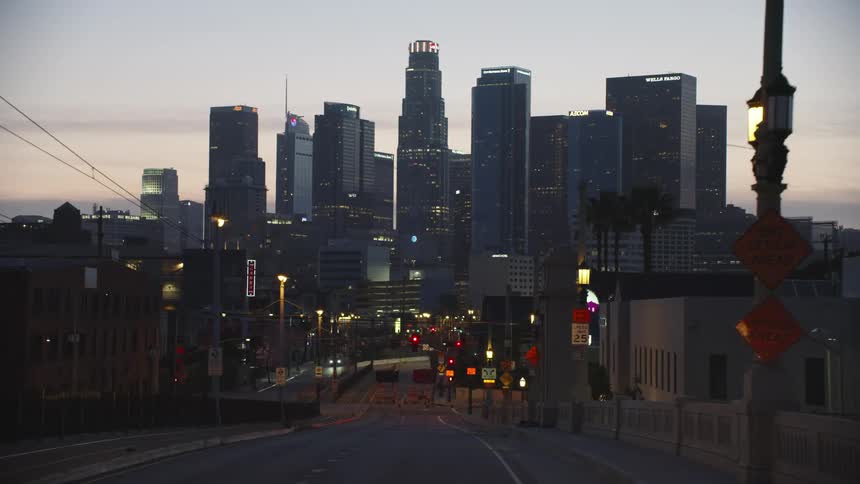 A closed road leading towards the downtown of a metropolis at sunset