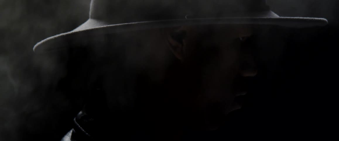 A man with a hat surrounded by smoke