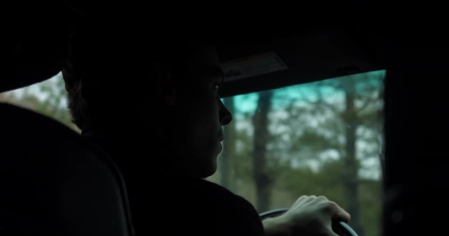 A man looking around while driving a car