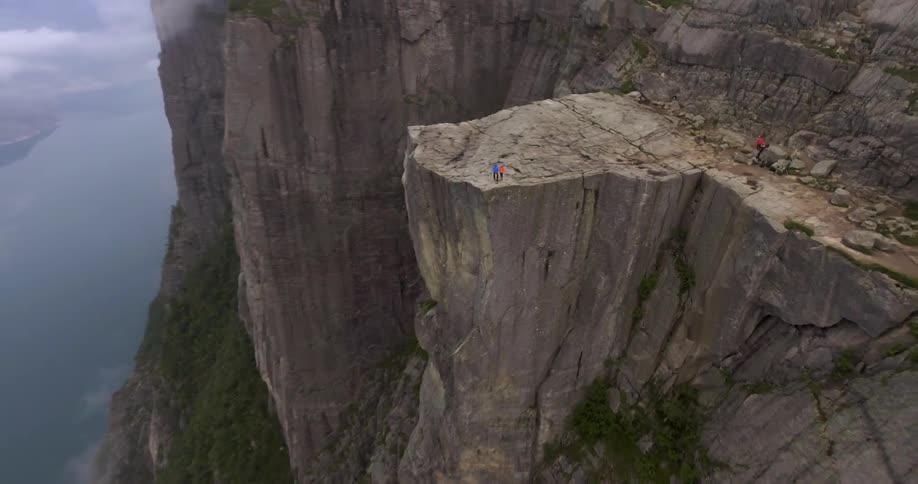 Two hikers stand on the edge of a cliff