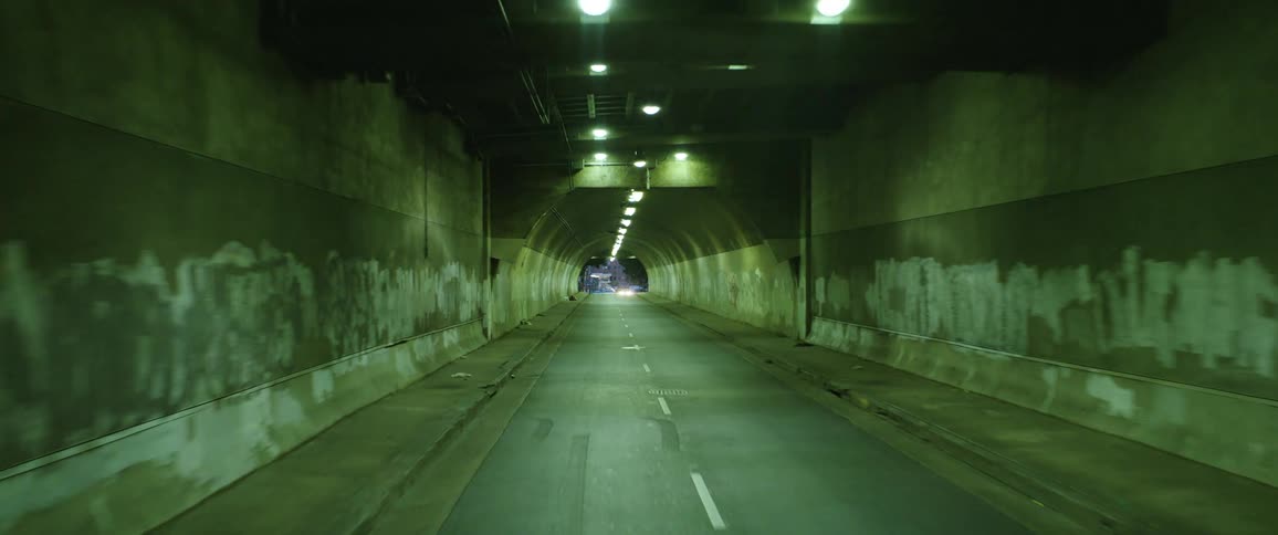Vehicle drives through a highway tunnel at night