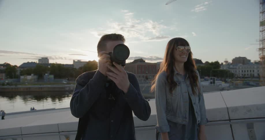 A man is taking photographs as a woman laughs