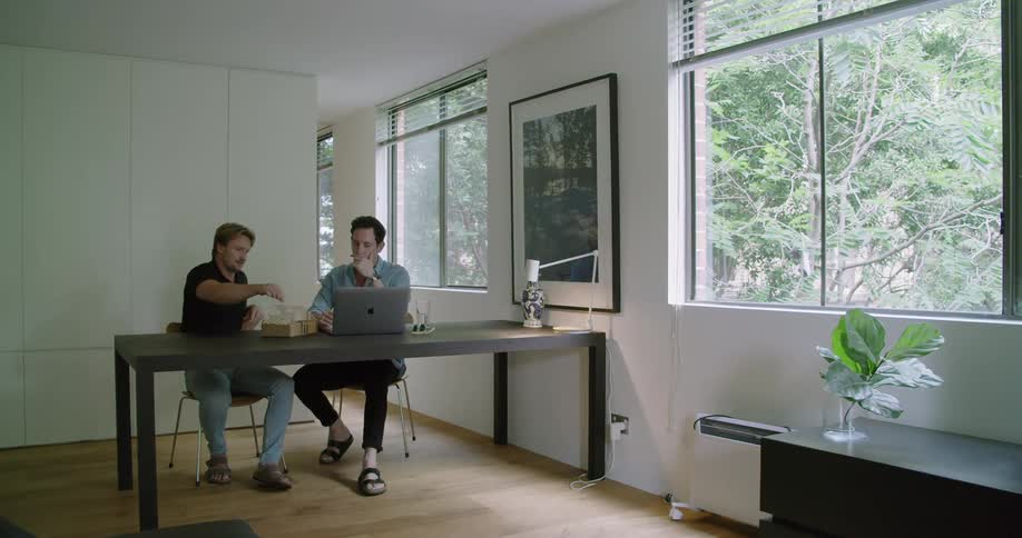 Two men working at a laptop together