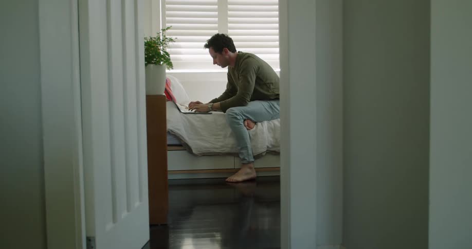 A man sitting up and working on a computer