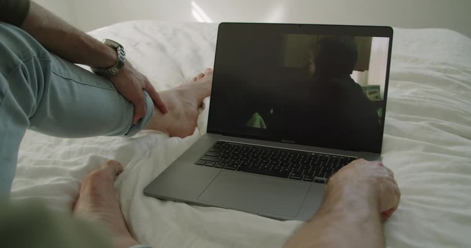 A man is watching a movie on the laptop