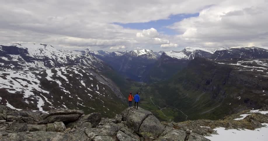 Two people stand side by side on a boulder