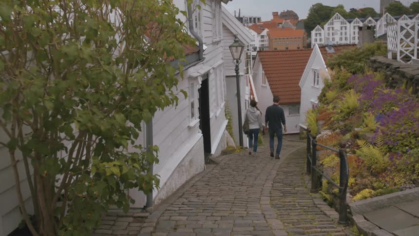Two people walk down a stone pathway