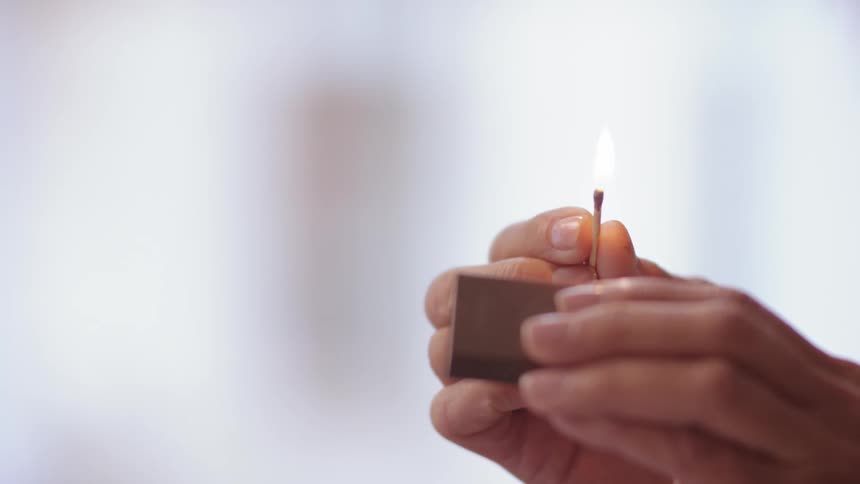 A close up of a person lighting a match