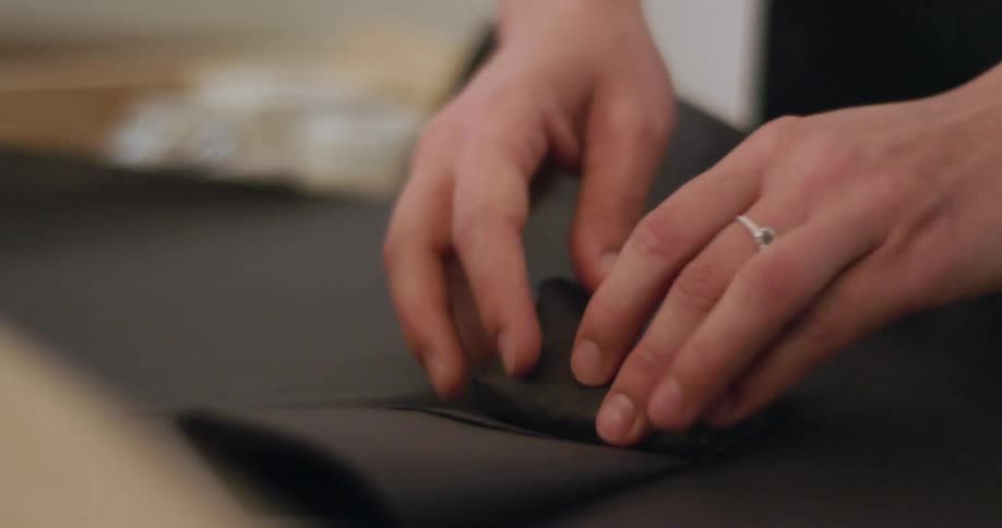 A woman wrapping an item up in tissue paper