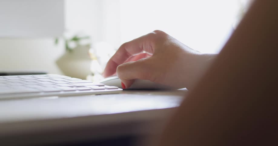 Person sits at table manipulating mouse