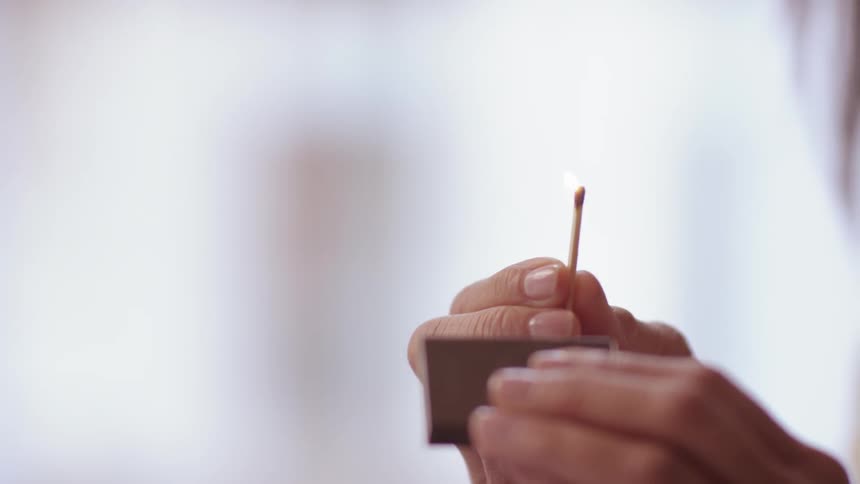 Striking a match on a matchbox and blowing out the flame