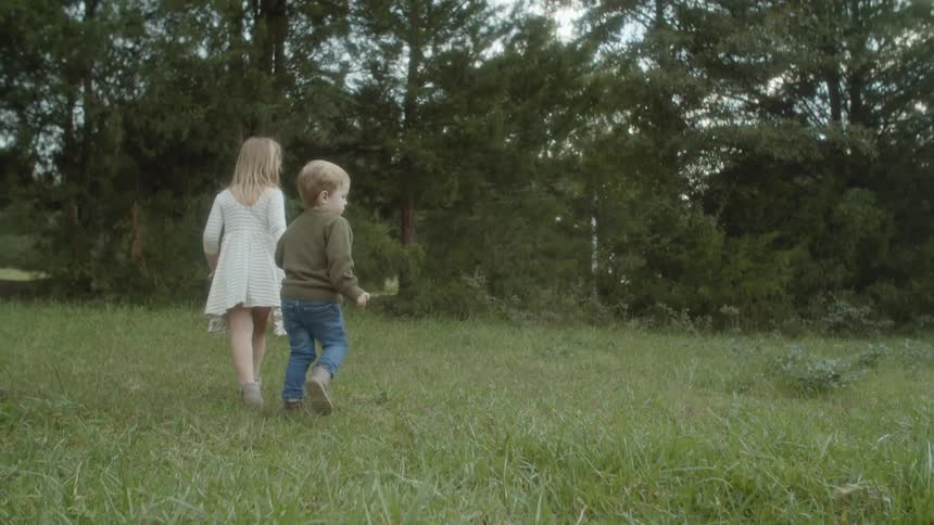 Two children playing in a grassy area