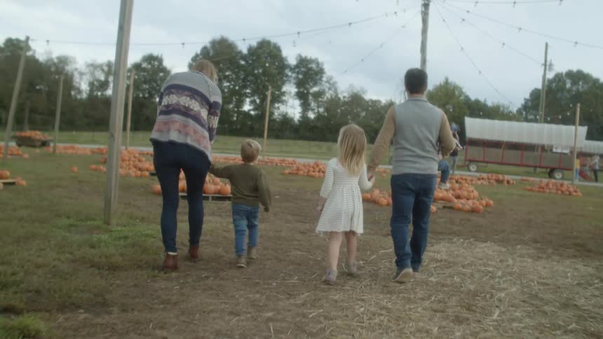 Family visits a pumpking patch in a open rural market