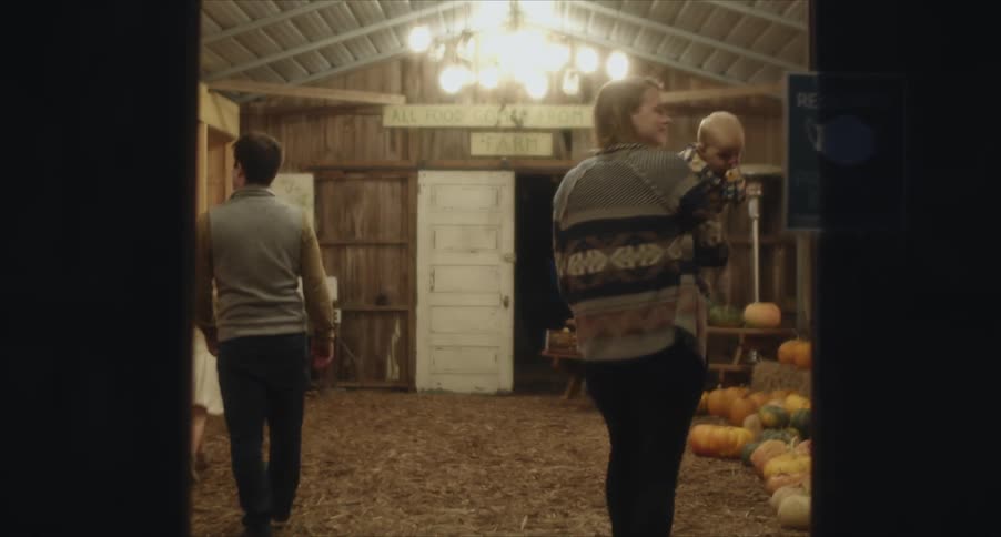 Family visiting a farmers market inside a barn