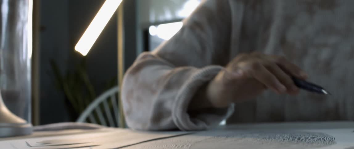 A person tapping on a drawing with a pen