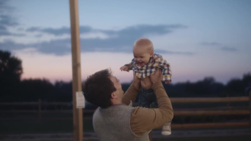 Father throwing son playfully in the air