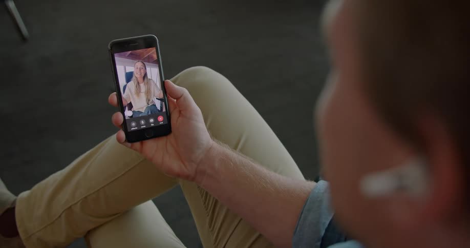 A man and woman video chatting on a cell phone