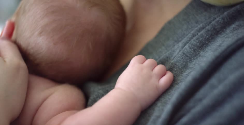 A mother holds her newborn baby close to her chest