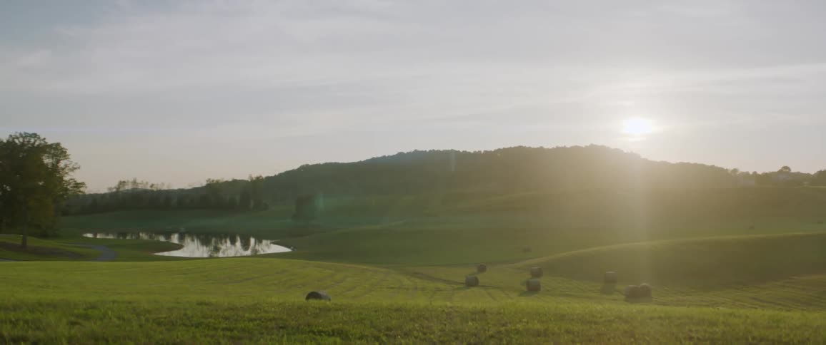 Sunset sunlight shining through the clouds over the green hills