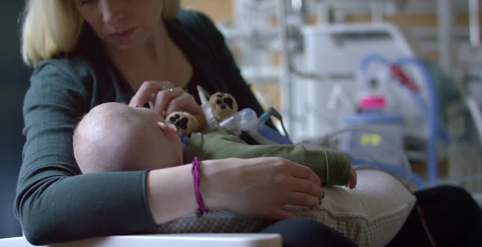 A woman is holding a baby in her arms in a hospital room