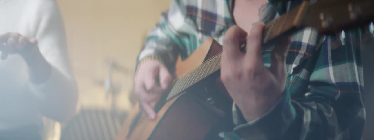 Two musician playing music with acoustic guitar inside a studio