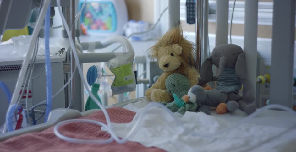 A crib is displayed with blankets and toys