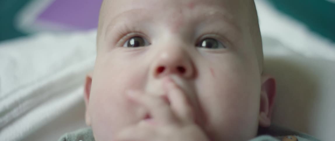 A baby puts its fingers in its mouth
