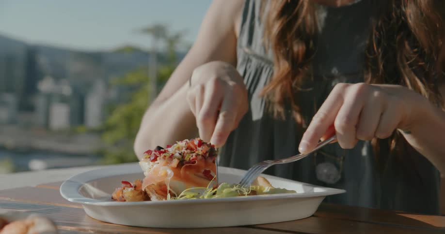 A woman is eating from a white plate