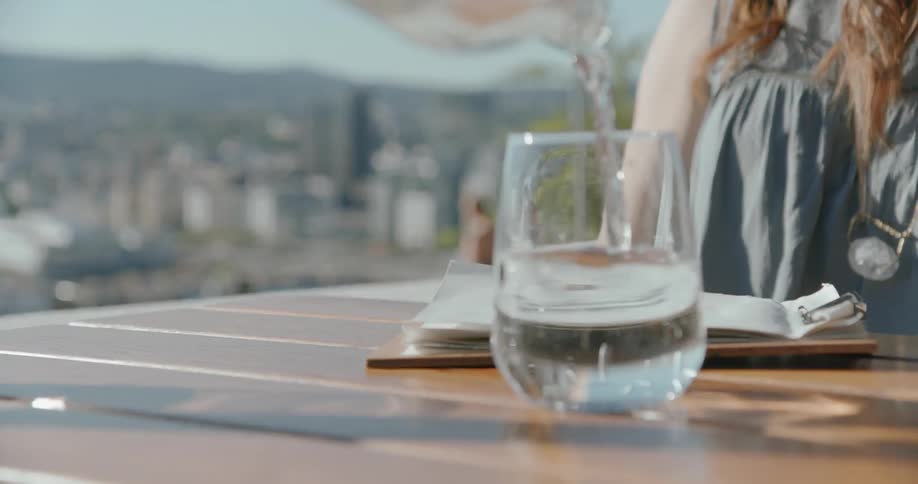 A person pours water into a glass