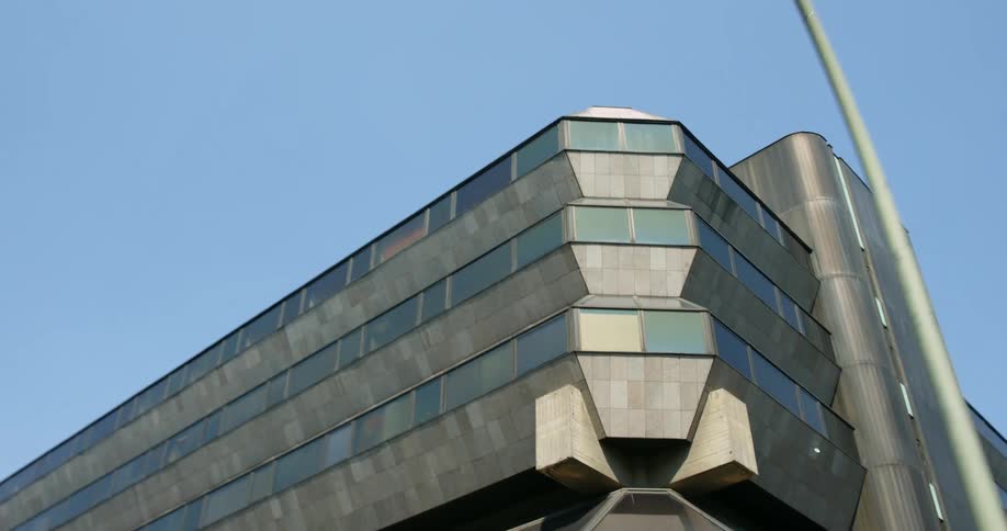 A corner of a futuristic building under a clear daytime sky