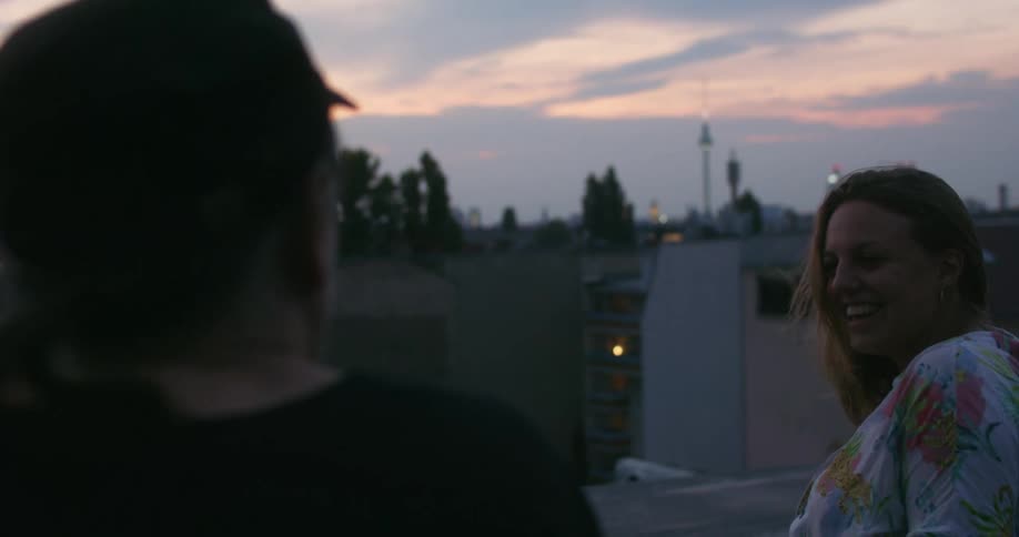 Two women talk and laugh on the roof