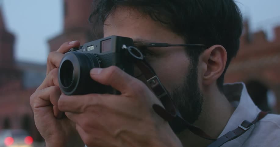 A man is standing outdoors with a camera