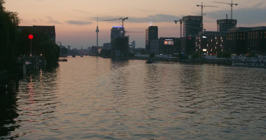 The sun is setting in the horizon of a downtown city