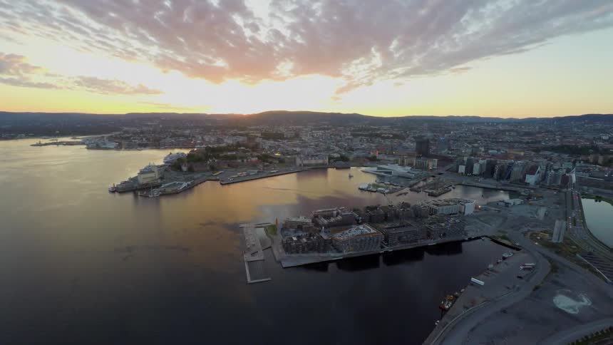 Aerial view of a city by the water at sunset