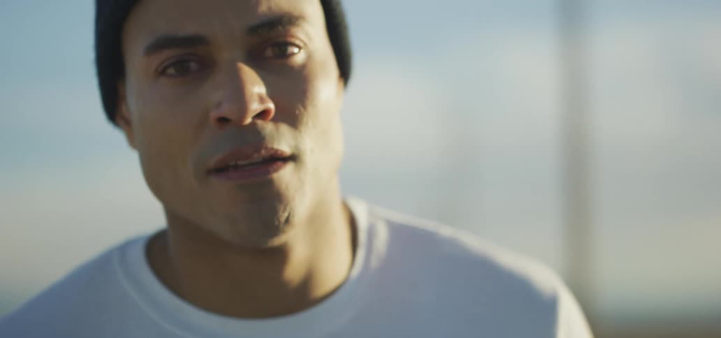 A man is standing outdoors at dusk