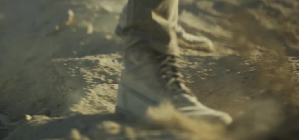A man kicking dirt with his boot