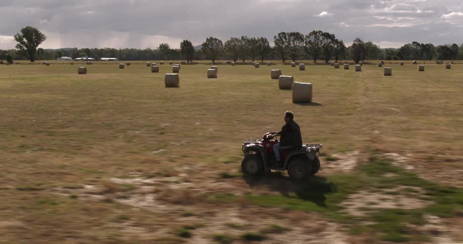 A man driving an atv through a farm