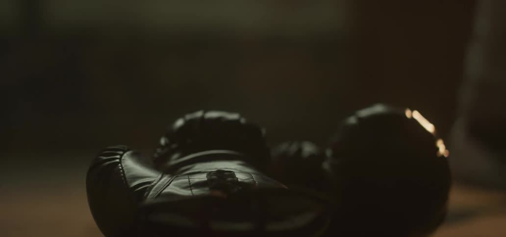 A person walks past boxing gloves